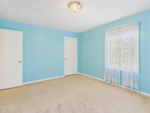 empty room with baseboards and carpet