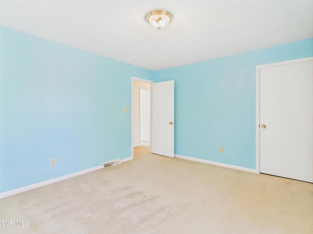spare room featuring carpet flooring, baseboards, and visible vents
