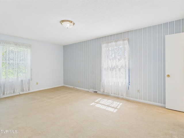 unfurnished room with carpet floors, baseboards, and visible vents