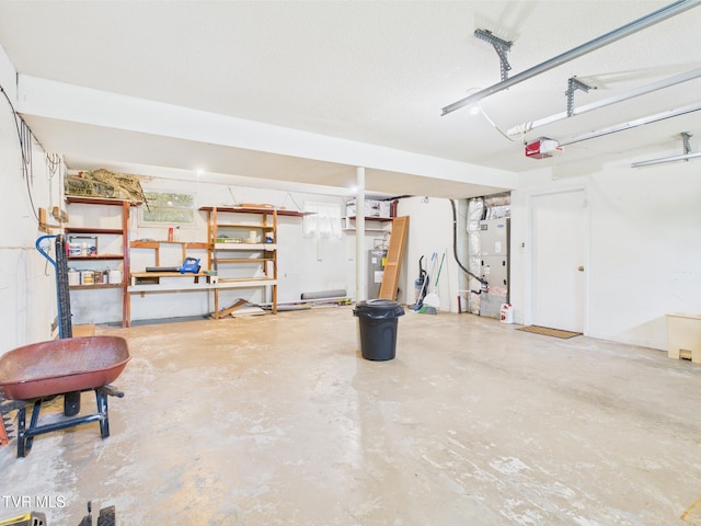 garage featuring a garage door opener, heating unit, and electric water heater