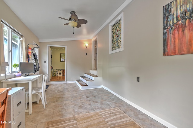 home office with baseboards, a ceiling fan, and stone finish flooring
