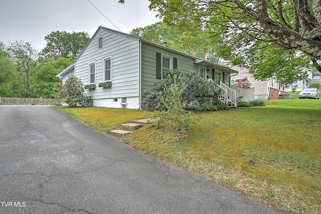 view of side of property featuring a lawn and fence
