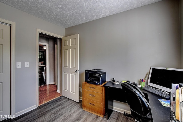 office featuring a textured ceiling, baseboards, and wood finished floors