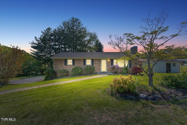 ranch-style home with a yard and brick siding