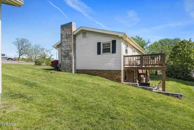 view of home's exterior with a chimney, a lawn, and a deck