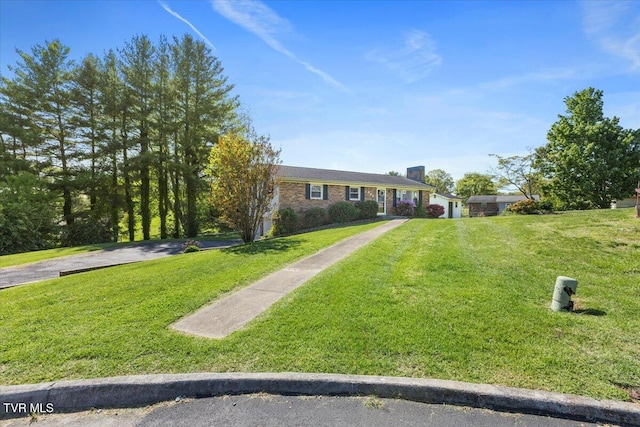 ranch-style house with brick siding, a front lawn, driveway, and a chimney