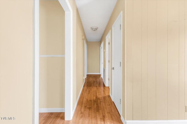 hall featuring baseboards and light wood-type flooring