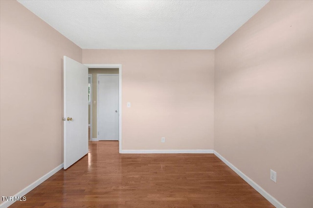 empty room featuring baseboards and wood finished floors