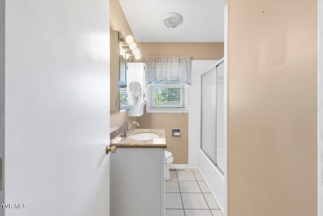 bathroom featuring combined bath / shower with glass door, tile patterned floors, vanity, and toilet