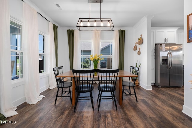 dining space with crown molding, baseboards, dark wood-style floors, and visible vents