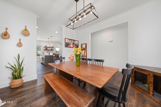 dining space featuring baseboards, dark wood-style floors, a notable chandelier, ornamental molding, and recessed lighting