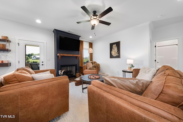 living area with ceiling fan, a large fireplace, baseboards, ornamental molding, and recessed lighting