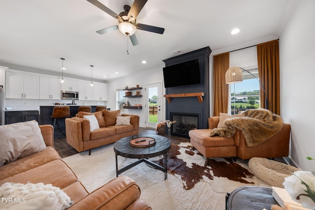 living room with recessed lighting, ceiling fan, and a fireplace
