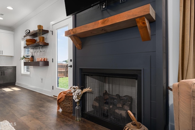 room details featuring a fireplace, wood finished floors, baseboards, ornamental molding, and recessed lighting