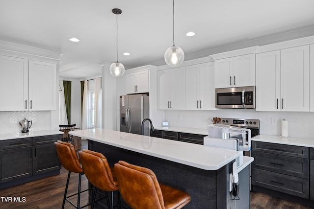 kitchen with light countertops, tasteful backsplash, white cabinets, and stainless steel appliances