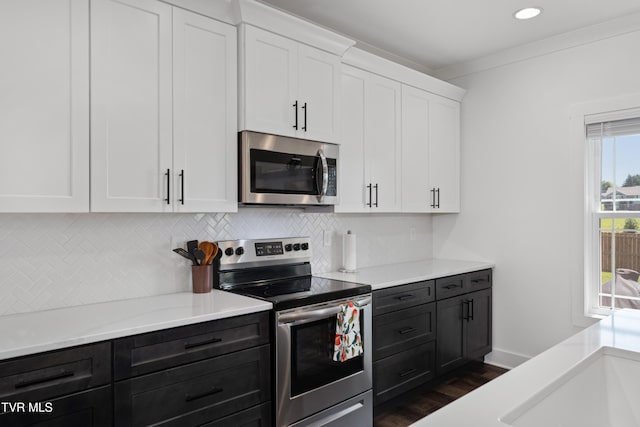 kitchen featuring white cabinets, appliances with stainless steel finishes, tasteful backsplash, and light countertops