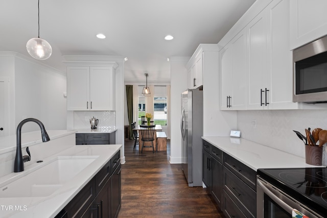 kitchen with a sink, decorative backsplash, white cabinets, and stainless steel appliances