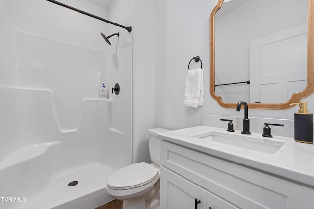 full bathroom featuring vanity, a shower stall, and toilet