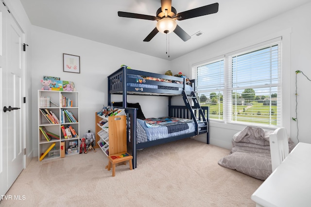 carpeted bedroom with ceiling fan and visible vents