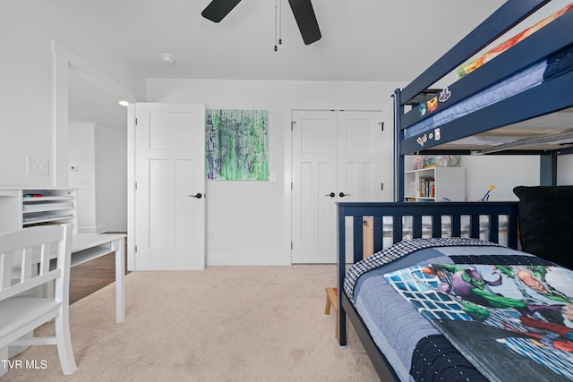 carpeted bedroom with ceiling fan, baseboards, and a closet