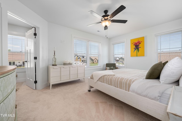 bedroom with baseboards, ceiling fan, visible vents, and light colored carpet