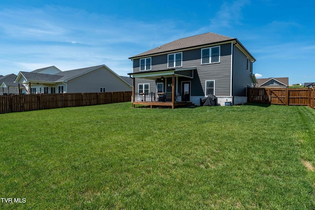 rear view of property featuring a fenced backyard and a yard