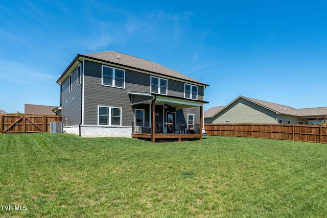 back of property featuring ceiling fan, a deck, cooling unit, a fenced backyard, and a lawn