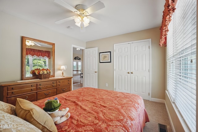 carpeted bedroom featuring visible vents, a ceiling fan, baseboards, and a closet