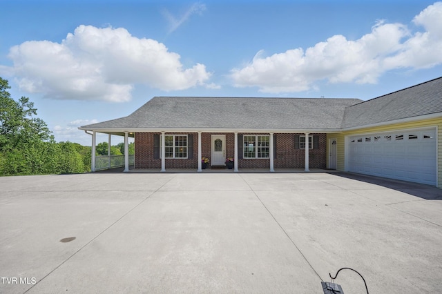 ranch-style home with an attached garage, a shingled roof, a porch, and concrete driveway