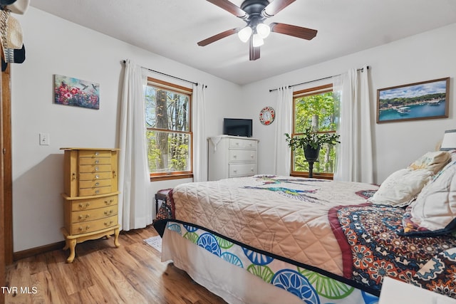 368 Burbank Rd, Roan Mountain, TN 37687 - bedroom featuring baseboards, multiple windows, a ceiling fan, and wood finished floors