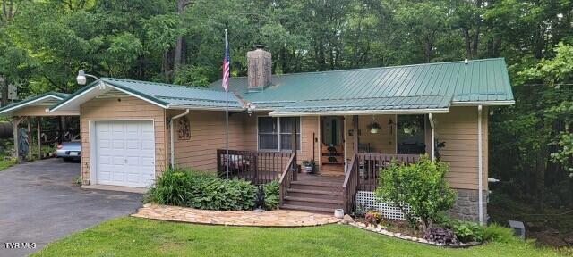 368 Burbank Rd, Roan Mountain, TN 37687 - view of front of home featuring asphalt driveway, a chimney, covered porch, metal roof, and an attached garage