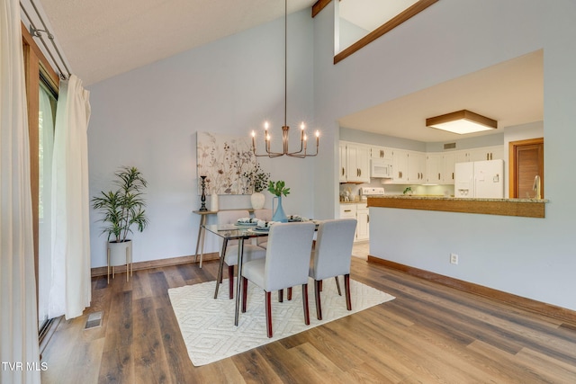 100 Periwinkle Pl Unit 100, Kingsport, TN 37660 - dining room with a chandelier, dark wood-type flooring, high vaulted ceiling, and baseboards