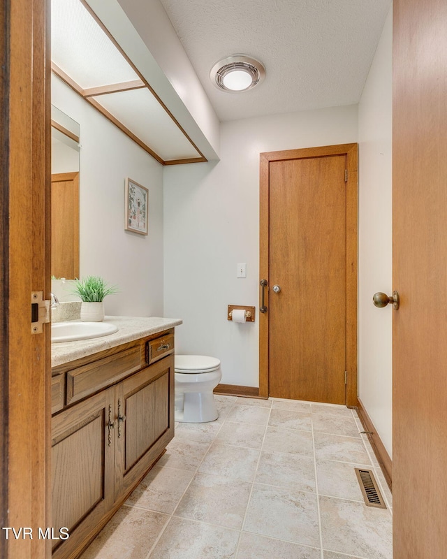 100 Periwinkle Pl Unit 100, Kingsport, TN 37660 - bathroom featuring toilet, vanity, a textured ceiling, and baseboards