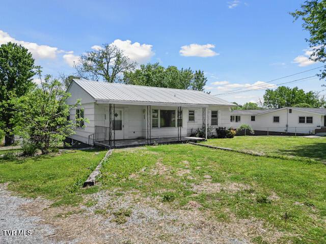 view of front facade with a front yard and metal roof