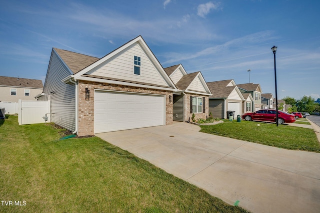 view of front of home featuring brick siding, driveway, fence, and a front lawn