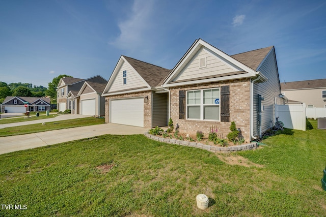 craftsman inspired home featuring fence, brick siding, a front yard, central air condition unit, and driveway