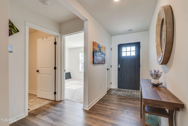 entrance foyer featuring visible vents, dark wood-style flooring, and baseboards