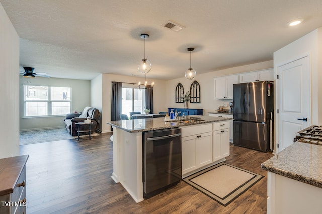 kitchen featuring visible vents, white cabinetry, appliances with stainless steel finishes, and an island with sink