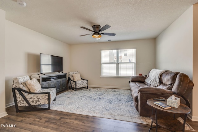 living room with baseboards, a textured ceiling, dark wood-style flooring, and ceiling fan