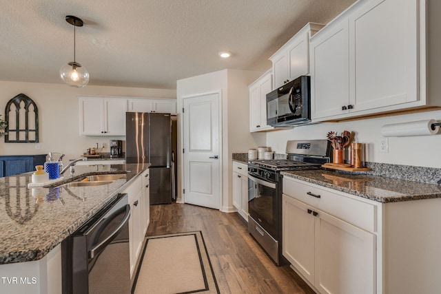 kitchen with dark wood-type flooring, a sink, a textured ceiling, and black appliances