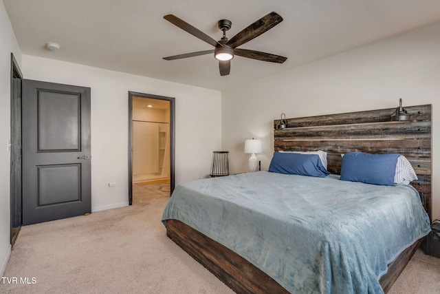 carpeted bedroom featuring baseboards, ceiling fan, and connected bathroom