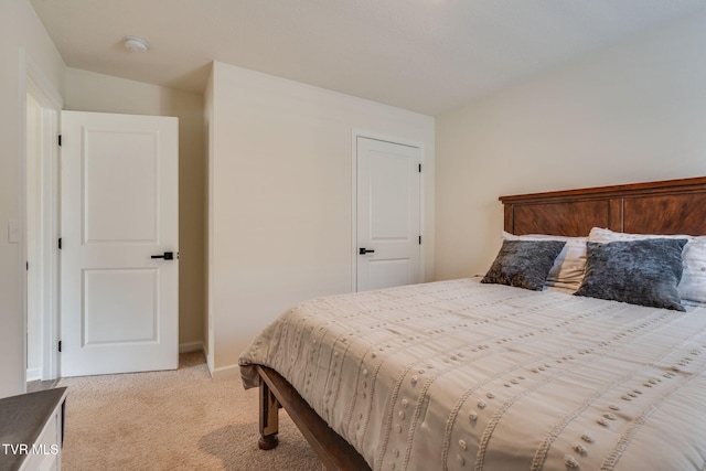 bedroom featuring baseboards and light colored carpet