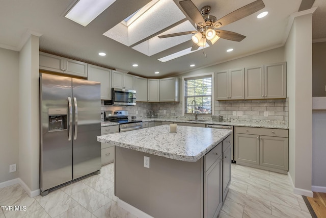 kitchen featuring stainless steel appliances, gray cabinetry, ornamental molding, and marble finish floor