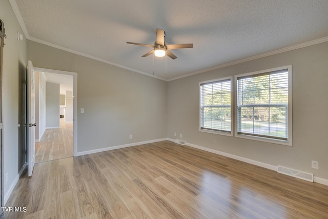 unfurnished room with a ceiling fan, light wood-type flooring, a textured ceiling, and visible vents