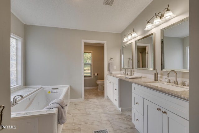 full bathroom featuring a sink, double vanity, toilet, marble finish floor, and a jetted tub