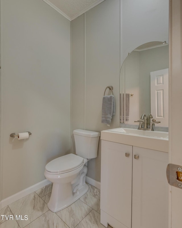 bathroom featuring crown molding, vanity, marble finish floor, toilet, and baseboards