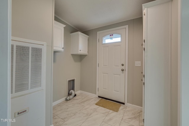 laundry room with crown molding, marble finish floor, cabinet space, and a heating unit