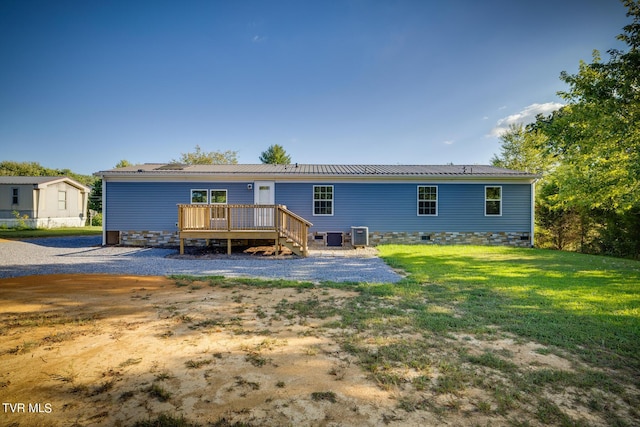 back of house with a deck, crawl space, cooling unit, a lawn, and metal roof