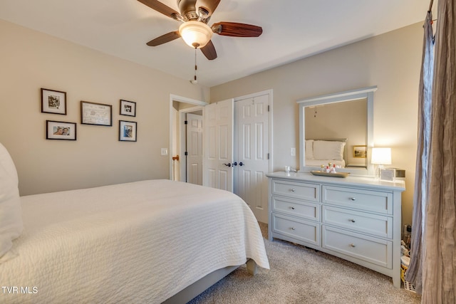 bedroom with light colored carpet, a ceiling fan, and a closet