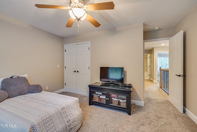 bedroom featuring baseboards, carpet, ceiling fan, and a closet